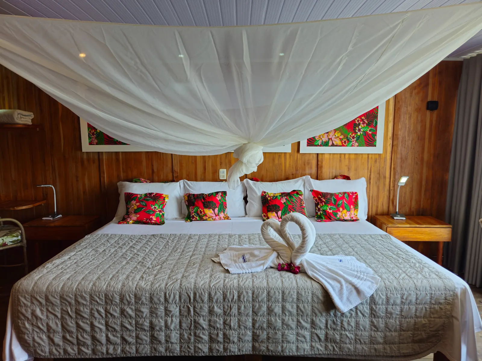Interior de uma Jaguar Suíte, com cama king, mosquiteiro e paredes de madeira